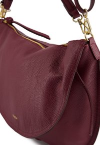 Bordeauxroter Lederhandtasche mit strukturierter Oberfläche, goldfarbenen Metallakzenten und einem Reißverschluss als oberen Verschluss. Verfügt über eine geschwungene Silhouette.