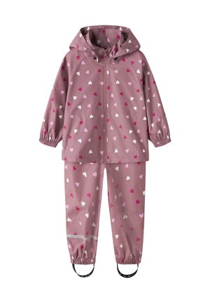 Tuta impermeabile per bambini rosa con motivo a cuori, giacca con cappuccio, polsini elasticizzati, zip frontale e pantaloni con caviglie elastiche e cinturini per i piedi.