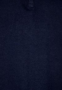 Marinblå bomullspolo med klassisk krage och en knapp samt en mjuk och slät textur. Inga synliga mönster eller detaljer.