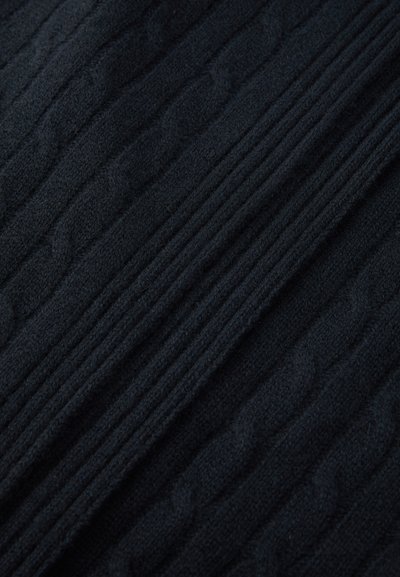 Knitted fabric in dark navy blue, featuring raised cable patterns and smooth texture with alternating ribbed sections.