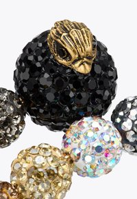 Bracciale di perline colorate con sfere nere, dorate e iridescenti con superfici sfaccettate; un dettaglio decorativo a forma di conchiglia in bronzo.