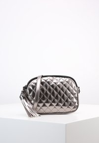 Borsa a tracolla argentata metallizzata con motivo trapuntato, chiusura con zip e dettaglio a nappina. Dispone di una tracolla sottile per un comfort ottimale.