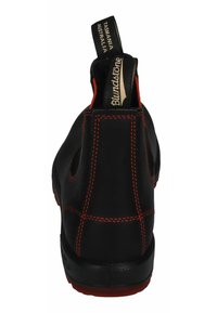 Black leather ankle boot featuring red stitching, elastic side panels, and a pull tab; durable sole with textured grip.