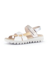 White and metallic gold sandal with a textured sole, adjustable strap, open toe design, and zigzag-patterned outsole.