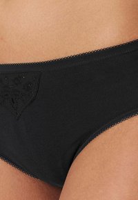 Schwarze Baumwollunterhose mit floralen Spitze-Akzenten an der Vorderseite, ausgestattet mit einer glatten Textur und einem elastischen Bund mit Picot-Trim.