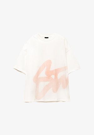 Weißes Baumwoll-T-Shirt mit einem großen, korallenroten, sprühlackierten Grafikdesign. Kurze Ärmel und lockere Passform. Glatte Textur.