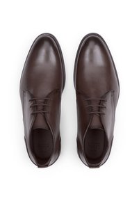 Bruine leren nette schoenen met een gladde afwerking, voorzien van veters, afgeronde neuzen en minimale stikdetails. Klassiek ontwerp op een vlakke zool.