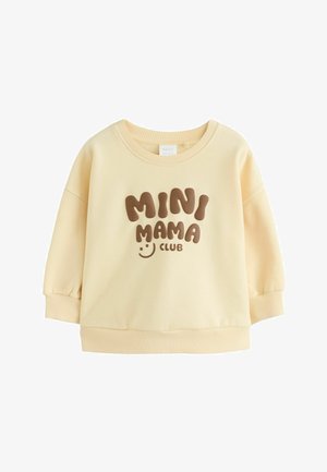 Bluza dla malucha w kolorze kremowym z prążkowanymi mankietami i dołem, z brązowym tekstem "MINI MAMA CLUB" i małą uśmiechniętą buźką.