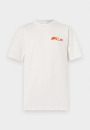 Λευκό κοντομάνικο T-shirt με στρογγυλή λαιμόκοψη και μικρό πορτοκαλί κείμενο "OBEY Racing Speed Squad" στο πάνω αριστερό μέρος του στήθους.