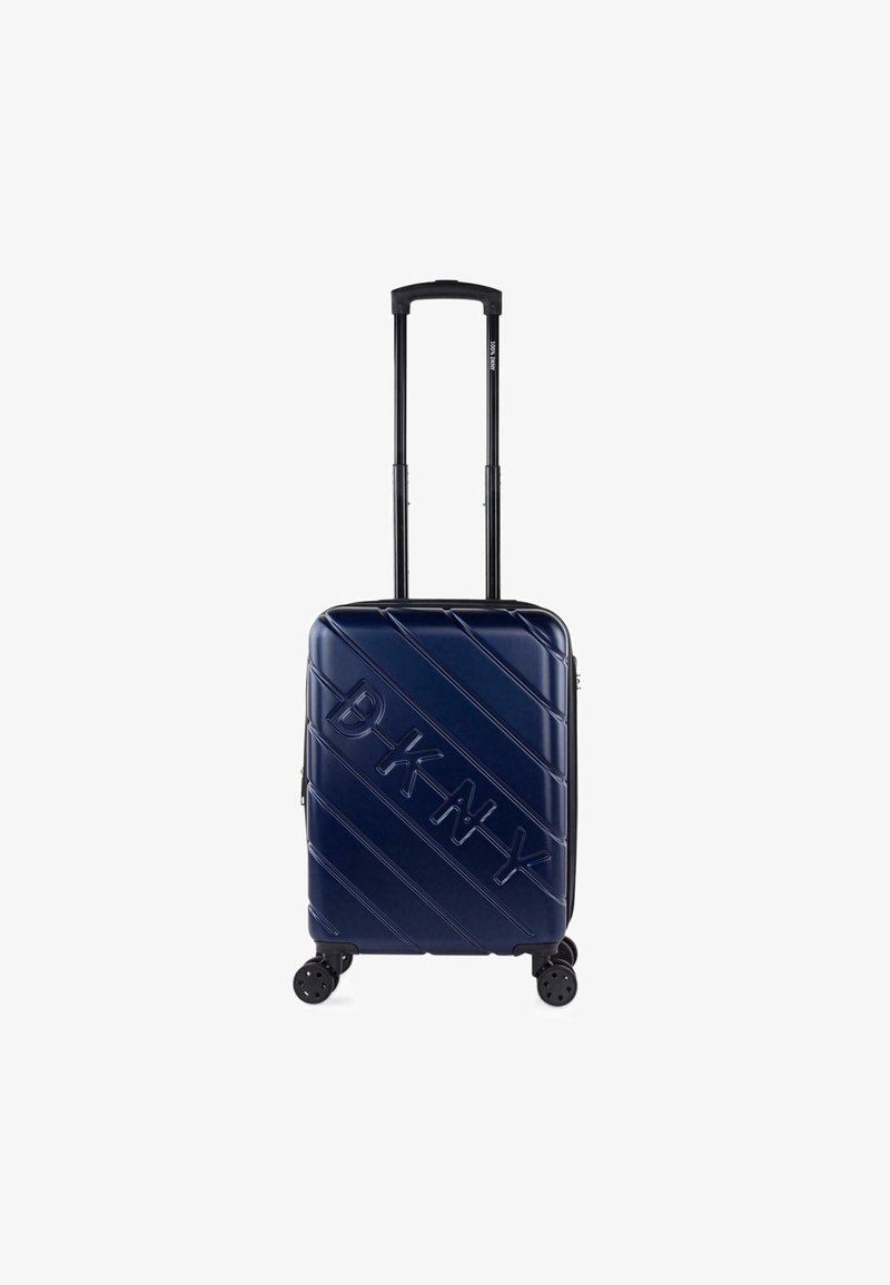 Maleta rígida de color navy con surcos diagonales, logotipo "DKNY" en relieve, mango retráctil y cuatro ruedas giratorias para una fácil movilidad.