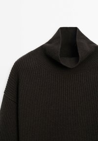 Pull en maille côtelée noire avec un col roulé plié, présenté sur fond blanc.