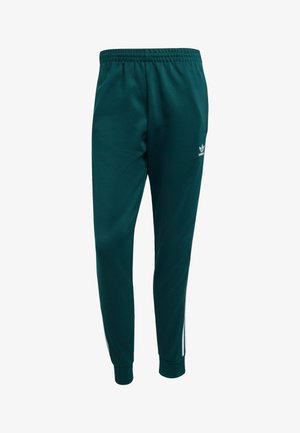 Zelene trenirke s elastičnim pojasom, sužavajućim rukavima i bijelim bočnim trakama. Sadrže Adidas logo u bijeloj boji na lijevom bedru.