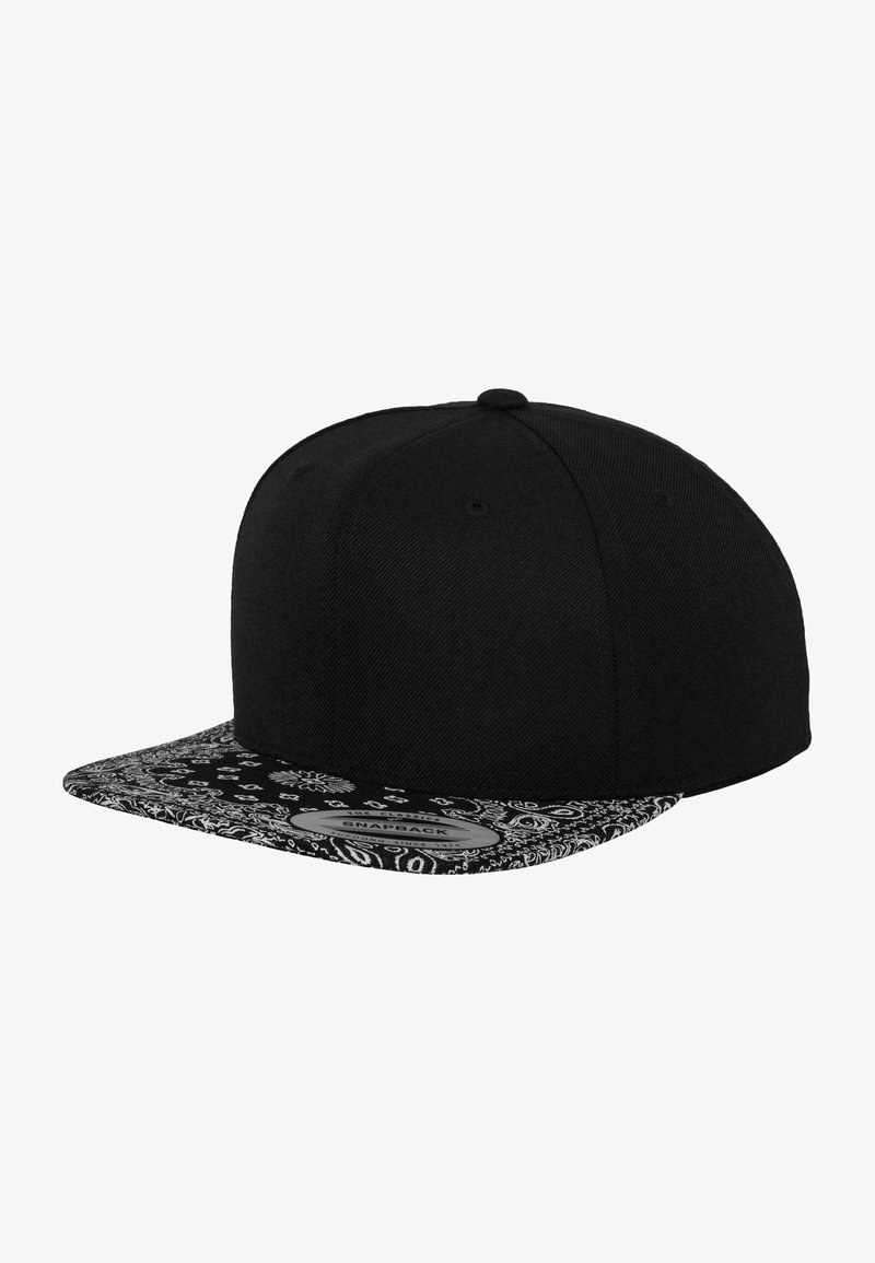 Gorra snapback negra con visera plana que presenta un interior con un patrón en blanco y negro. Fabricada en tejido con un acabado texturizado.