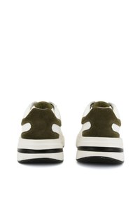 Sneaker verde in suede e bianco in pelle con una suola spessa, che mostrano una texture liscia, accenti a contrasto e una forma del tallone arrotondata.