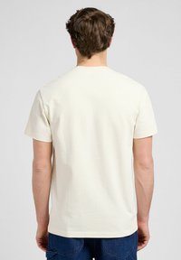 Lys cremefarvet kortærmet t-shirt lavet af bomuld, med rund halsudskæring og glat tekstur, med et minimalistisk design uden udsmykninger.
