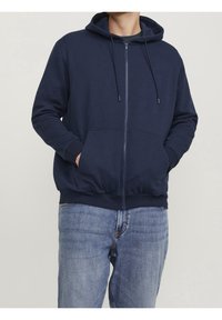 Felpa con zip blu navy in cotone, dotata di cappuccio, lacci e tasche frontali. Tessuto testurizzato con un taglio comodo.