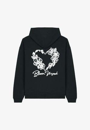 Sudadera negra con un gran diseño de corazón floral blanco en la parte posterior, con el texto "Bloom Mood" debajo. Textura suave, estilo casual.
