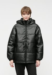 Czarna pikowana kurtka z błyszczącym wykończeniem, z kapturem, zamkiem z przodu, regulowanym sznurkiem oraz elastycznymi mankietami. Posiada obszerne kieszenie boczne.