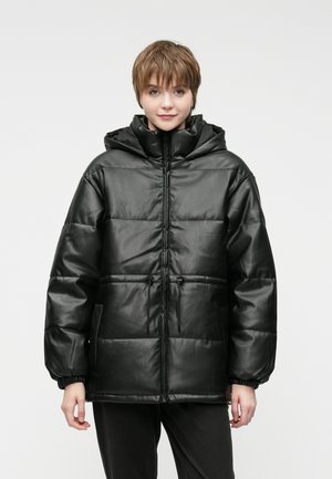 Czarna pikowana kurtka z błyszczącym wykończeniem, z kapturem, zamkiem z przodu, regulowanym sznurkiem oraz elastycznymi mankietami. Posiada obszerne kieszenie boczne.