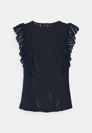 Haut bleu marine avec un col rond, présentant des découpes œillets en motif chevron et des manches volantes pour une texture supplémentaire.