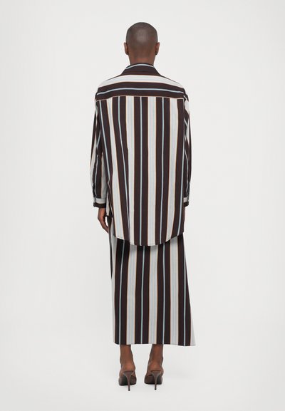 Striped shirt and skirt set in dark brown, light blue, and beige. Fabric is smooth with a loose fit. Features long sleeves and a high low hem.