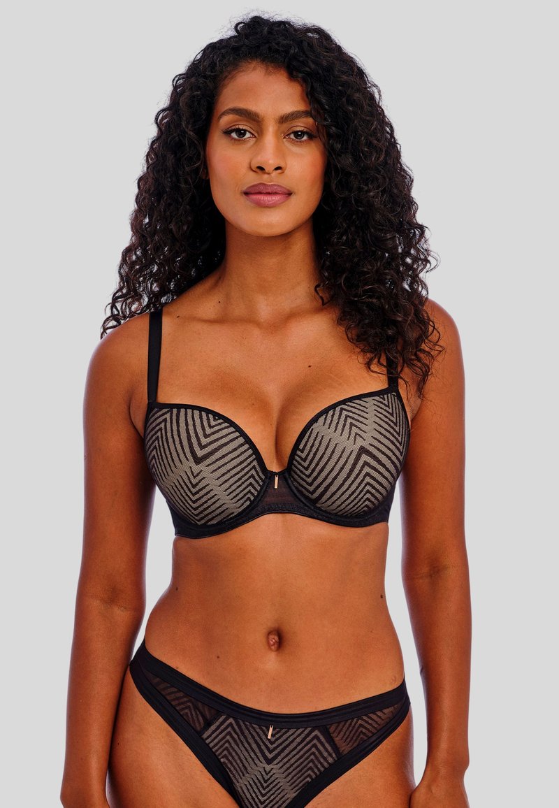 Schwarzes und beiges Dessous-Set mit einem semi-transparenten BH mit Chevron-Muster, unterstützenden Bügeln und passenden Slips mit dünnen Bändern.