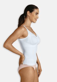 Witte geribde tanktop met een ronde halslijn en verstelbare bandjes, in combinatie met lichtroze ondergoed. Glad textuur, aansluitend ontwerp.