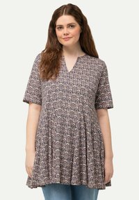 Tunique à motif floral en bleu marine et beige, avec des manches courtes, un col en V et une silhouette fluide avec des détails froncés.
