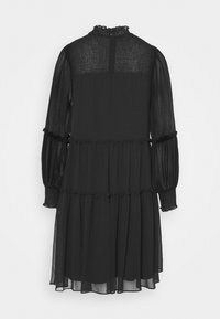 Robe noire longueur genou avec manches longues transparentes, col montant froncé et poignets, jupe à volants et empiècement texturé au dos.
