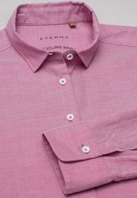 Růžová cyklistická košile ETERNA s límečkem na knoflíky, bílými knoflíky a kontrastním prošíváním. Měkká tkanina s jemnou strukturou.