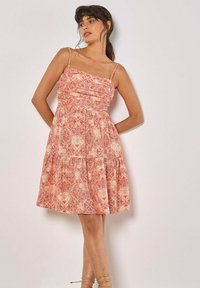 Robe sans bretelles avec un corsage froncé dans un motif floral orange et crème ; jupe évasée, longueur genou, tissu léger et fines bretelles.