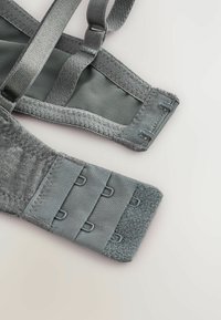 Fascia grigia della bralette con spalline regolabili, tessuto testurizzato, chiusure a gancio e occhiello multiple e fodera in morbido mesh per il comfort.