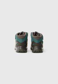 Botas de caminhada de altura média com parte superior em malha azul-verde e detalhes em castanho escuro, apresentando uma sola em borracha texturizada e tiras ajustáveis no tornozelo.