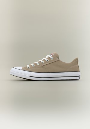 Madalad beežid lõuendist tossud valge kummist tallaga, valgete paelte ja musta triibuga detailiga neutraalsel taustal.