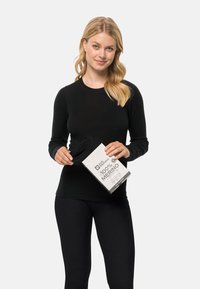 Schwarzes langärmliges Merino-Baselayer-Oberteil, gehalten von einer Person mit hellbraunem Haar, mit einer Box, die "100% Merino" in Grau und Schwarz zeigt.