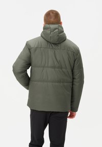 Gevoerde jas in olijfgroen, met een capuchon, horizontale stiksels en een relaxte pasvorm. Het materiaal lijkt zacht en waterafstotend.