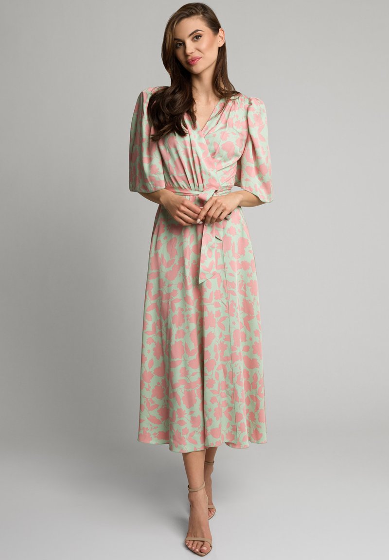 Kwiatowa sukienka w kolorze miętowym z różowymi akcentami, z rękawami o długości trzech czwartek, z wiązaniem w talii i spódnicą o średniej długości.