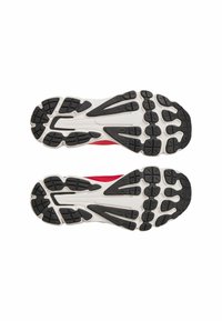 Red athletic shoes with a textured black rubber sole featuring various grip patterns and a white midsole for cushioning.