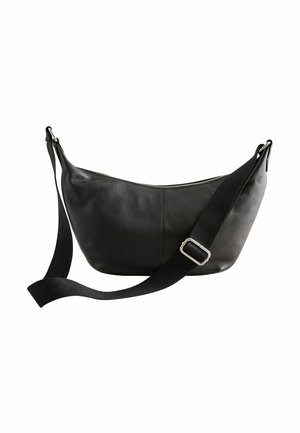 Sac bandoulière en cuir noir avec sangle en tissu noir réglable et boucle argentée, fermeture éclair sur le dessus, design simple et arrondi.