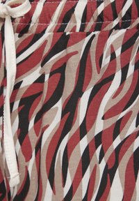 Katoenen shorts met een levendig abstract patroon van rode, zwarte en beige golvende lijnen. Elastische tailleband met een trekkoord.