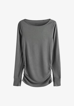 Hallikas pikkade varrukatega ülikerge ja venivast kangast pluus, millel on kausskaelus, külje kokkutõmbe detail ja liibuvad varrukad.