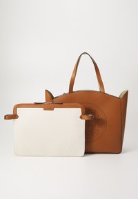 Sac cabas en cuir marron avec un design perforé circulaire et une pochette rectangulaire blanche avec bordure en cuir marron et fermeture éclair à l'avant.