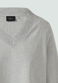 Hellegrauer V-Ausschnitt-Pullover mit geripptem Kragen, der mit kleinen silbernen Pailletten verziert ist, aus weichem strukturiertem Stoff.