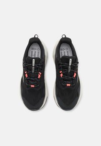 Zwarte sportschoenen met een bovenwerk van mesh, contrasterende roze accenten, ronde veters en een gestructureerde zool. Voorzien van een gevoerde inlegzool.