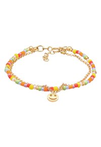 Bracelet doré avec des perles colorées en rouge, jaune, vert et bleu, accompagné d'un charme en forme de visage souriant et d'un design en maillons.
