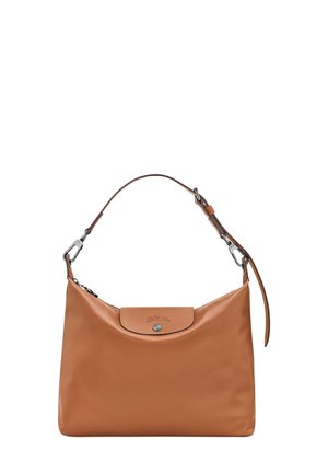 Tan leather shoulder bag with a smooth texture and rounded shape. Features a top flap with a silver snap closure and an adjustable strap.