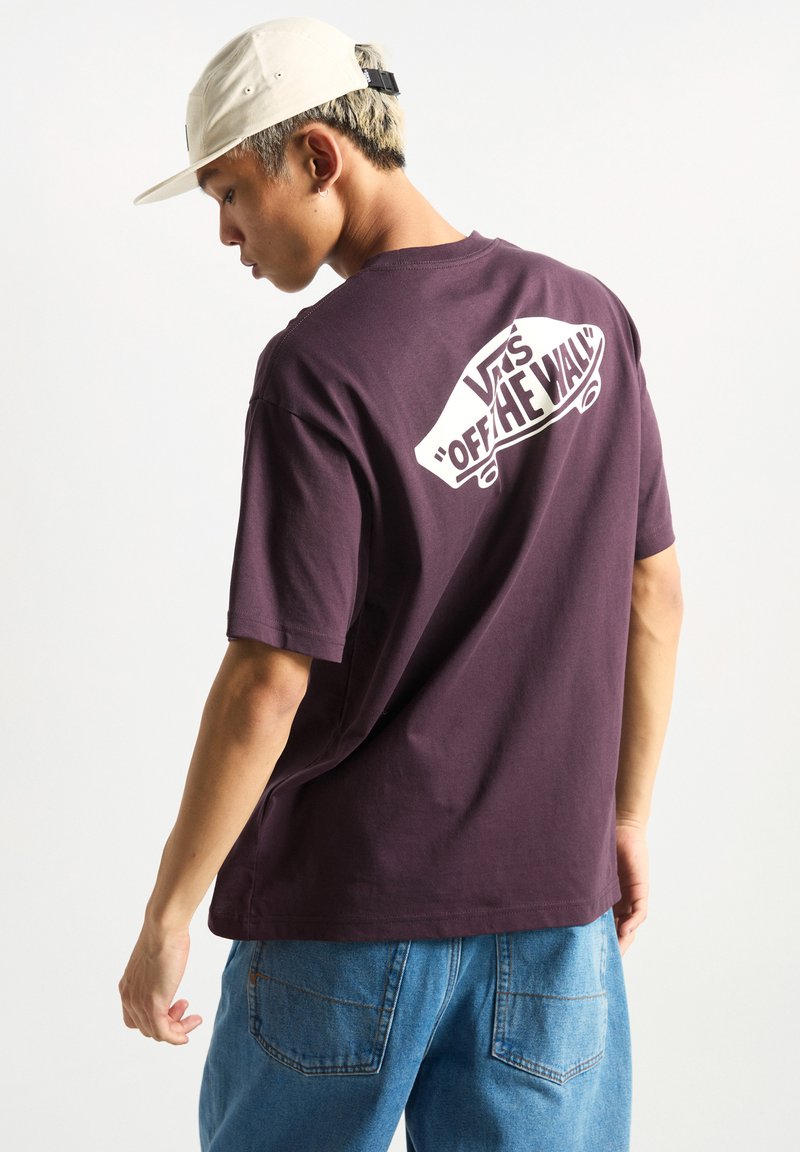 Maročná bavlněná tričko s krátkým rukávem, na zadní straně s bílým grafikou "VANS 'OFF THE WALL'". Nosit s modrými džíny.