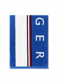 Blauwe handdoek met witte strepen en rode en zwarte accenten. Grote letters die "GER" in het wit spellen. Zacht, pluchen textuur.