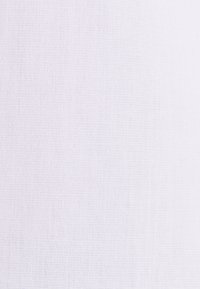 Witte stof met een fijne, gestructureerde weving. Effen oppervlak met minimale variaties, wat zorgt voor een zachte en gladde uitstraling.