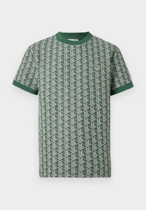 Grünes kurzärmeliges Hemd mit geometrischem weißem Muster, grünem Kragen und Ärmelsäumen sowie einem kleinen, gestickten Krokodil-Logo auf der Brust.